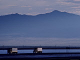 Trucks Along the Highway Next to Great Salt Lake, Utah Photographic Print by Kenneth Garrett