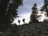 Two Hikers Ascend a Rocky Ridge Among Pines Photographic Print by Dawn Kish