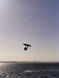The Silhouette of a Person Kite Surfing, in a Choppy Windswept Bay, Australia Photographic Print by Jason Edwards