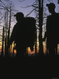 Silhouette of Two Backpackers in Front of Bare Trees after Sunset Photographic Print by Dawn Kish