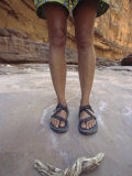 The Legs and Sandal Clad Feet of a Woman with Driftwood in a Canyon Photographic Print by Dawn Kish