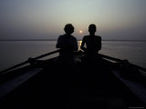Silhouettes of Boatmen Rowing at Dawn on the Holy Ganges River Photographie par Jason Edwards