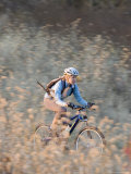 Woman Mountain Biker Rides Trail Through Fields Photographie par Skip Brown