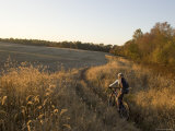 Woman Mountain Biker Rides Through a Field Photographie par Skip Brown