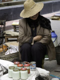 Vendor at a Local Market Hiding Behind the Brim of Her Straw Hat, Qinghai, China Photographie par David Evans