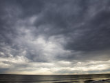 Sun Streams Through Gathering Storm Clouds on North Carolina Coast Photographic Print by David Evans