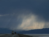 Storm over the Pilot Mountains and Trucks Traveling over Salt Flats, Utah Fotografisk trykk av James P. Blair Storm over the Pilot Mountains and Trucks Traveling over Salt Flats, Utah Fotografisk trykk av James P. Blair