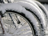 Snow Covered Bicycles Parked in Town Photographic Print by Kate Thompson