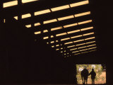 Silhouette of a Woman with Her Horse Walking Out of Barn Photographie par Kate Thompson