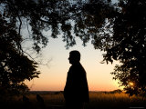Young Teenager Watches the Sun Set on a Farm in Nebraska Photographie par Joel Sartore