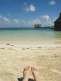 Womens Feet on the Beach with a View of the Ocean, Pier and Boats, Ambergris Caye, Belize Photographic Print