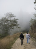 Two Men Walk Up a Foggy, Andean Dirt Road, Venezuela Photographie par David Evans
