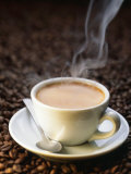 A Steaming Cup of Coffee on Coffee Beans Photographic Print by Peter Sapper