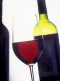 A Glass of Red Wine with a Bottle in the Background Photographie par Armin Faber