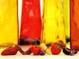 Various Types of Peppers in Front of Red & Yellow Bottles Fotografie-Druck von Monica Varella