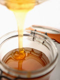 Organic Honey Running into a Honey Jar Photographic Print by Paul Blundell
