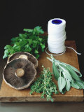 Mushrooms, Fresh Herbs & Kitchen String on Chopping Board Photographic Print by Michael Paul