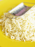 Grated Cheese with Grater on Yellow Plate Photographic Print by Dave King