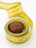 Chocolate Truffle Lying in Rolled-Up Tape Measure Photographic Print by Elisabeth Cölfen