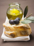 Olive Sprig with Black Olives on White Bread, Olive Oil Behind Fotografie-Druck