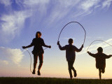 Silhouette of Children Jumping Rope Outdoors Photographic Print by Mitch Diamond