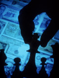 Hand Holding Chess Piece in Front of Currency Photographic Print by Gary Conner