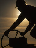 Silhouette of Oil and Gas Worker Turning Valve Fotografisk trykk av Kevin Beebe Silhouette of Oil and Gas Worker Turning Valve Fotografisk trykk av Kevin Beebe