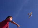 Boy Flying Toy Airplane Photographie par Kevin Leigh