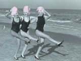Three Women on Beach with Pink Towels on Head Photographie par Jim McGuire
