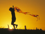 Child Flying a Kite at Sunset Photographic Print