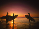 Three Surfers Hold Surfboards on Beach at Sunset Photographic Print by Doug Mazell