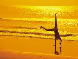 Girl Doing Cartwheels on Beach at Sunset Photographic Print by Jennifer Broadus
