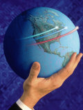 Businessman's Hand Holding Globe Photographic Print by Guy Crittenden