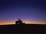 Silhouette of Worker Cutting Grass at Sunrise Photographic Print by Kent Dufault