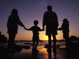 Famille à la plage au soleil couchant Photographie