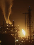 Des étincelles et des flammes illuminent le ciel nocturne sur le site d'une centrale électrique Photographie par Sam Kittner
