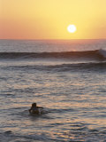 A Woman Paddles out to Sea for Sunset Surfing Photographic Print by Jimmy Chin