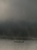 On a Stormy Evening, a Lone Boater Floats Beneath an Ominous Sky Photographie par Sam Kittner