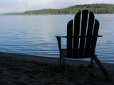 An Adirondack Chair Silhouetted by a Lake Photographic Print by Stacy Gold