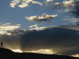 Silhouetted Figure Trail Running under a Cloud Filled Sky Photographic Print by Bobby Model