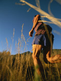 A Man Runs Through Tall Grass Near Mt. Elden Photographic Print by John Burcham