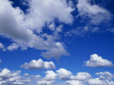 Sunlit Fluffy White Clouds in a Blue Sky Photographie par Jason Edwards