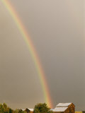 A Rainbow Arches Across the Sky onto a Cluster of Farm Buildings Photographic Print by Michael S. Lewis