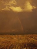 Storm Clouds and a Rainbow Appear over the Prairie Landscape Photographic Print by Paul Damien