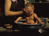 A Bhutanese Woman Bathes Her Baby in a Large Metal Bowl Photographic Print by James L. Stanfield