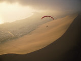 El viento marino mantiene en el aire a un parapente sobre Cerro Dragón, una duna desértica Lámina fotográfica por Joel Sartore El viento marino mantiene en el aire a un parapente sobre Cerro Dragón, una duna desértica Lámina fotográfica por Joel Sartore