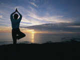 A Woman Practices Yoga on the Beach at Sunset Photographie par Roy Toft