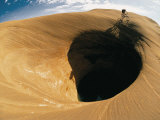 A Mountain Biker Cycles Around a Spectacular Crater in the Desert Fotografisk trykk av Dugald Bremner