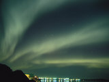 The Northern Lights Create Fantastic Patterns over a City Photographic Print by Paul Nicklen