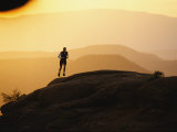 A Woman Runs on Red Rocks Photographic Print by Dugald Bremner